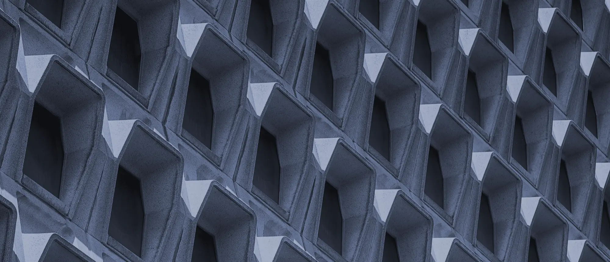 A repeating grid of cast-concrete window bays across a modernist facade.